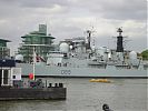 HMS Exeter being tugged up the Thames
